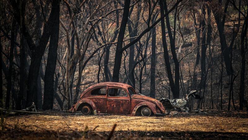 The remains of a car that was destroyed by bushfires sits near a home in the town of Balmoral in Australia. Photograph: David Gray/Getty Images