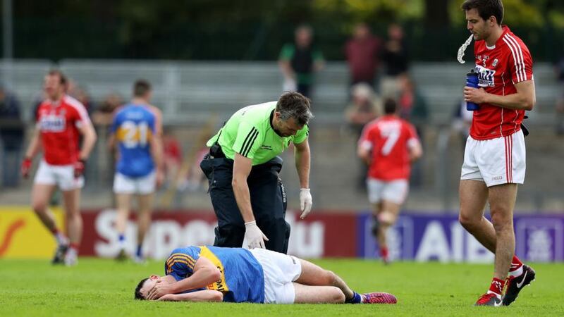 Tipperary’’s Michael Quinlivan receives attention after picking up the ankle injury that ended his involvement. Photograph: Tommy Dickson/Inpho