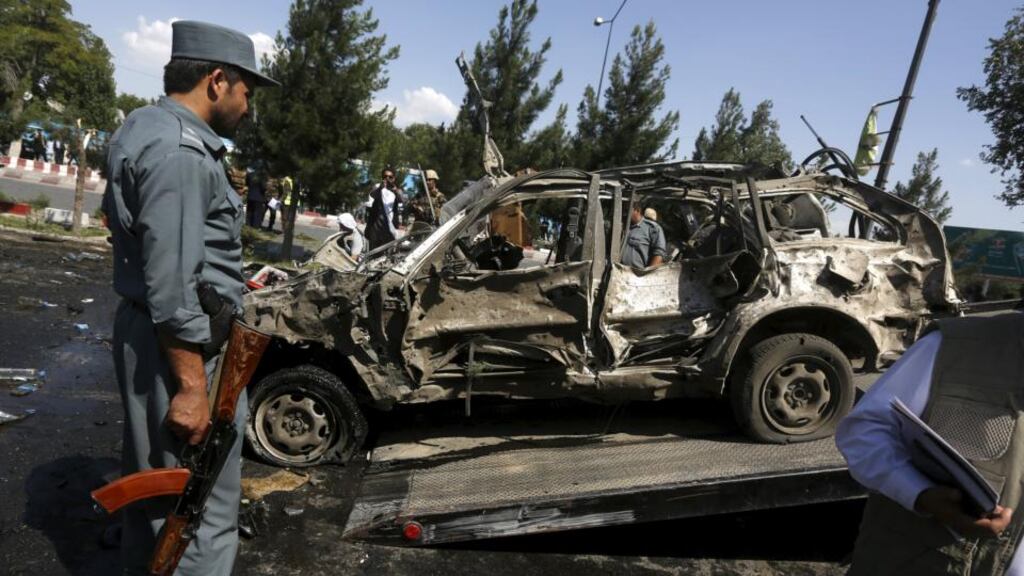 An Afghan policeman inspects the site of a suicide bomb attack on a Nato convoy in Kabul, Afghanistan. Photograph: Omar Sobhani/Reuters