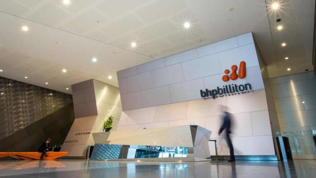A man walks through the foyer of the BHP Billiton  headquarters in Melbourne. The company has reported a 30 per cent decline in full-year profit. Photo: Bloomberg