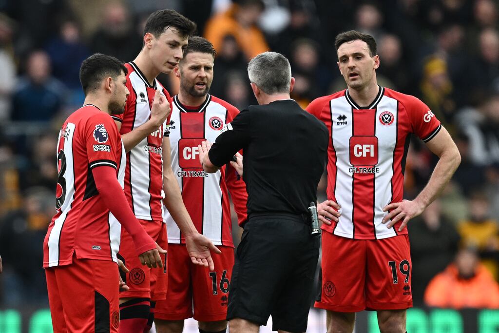 Referee Darren Bond speaks with Sheffield United defender Jack Robinson (right) after an incident with his team-mate Vinícius Souza during the Premier League match against Wolves at Molineux. Photograph: Paul Ellis/AFP via Getty Images