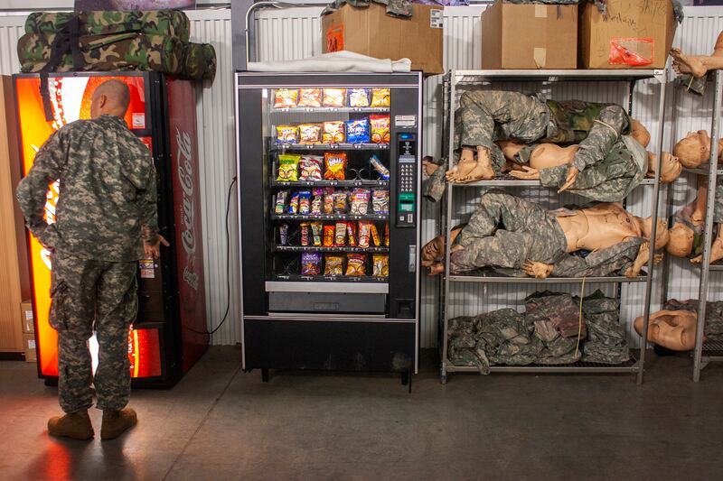 Strange Love: a serviceman buys a cold drink beside a pile of dummies used for training in battle first aid, Fort Riley, Kansas, US. Photograph: Seamus Murphy