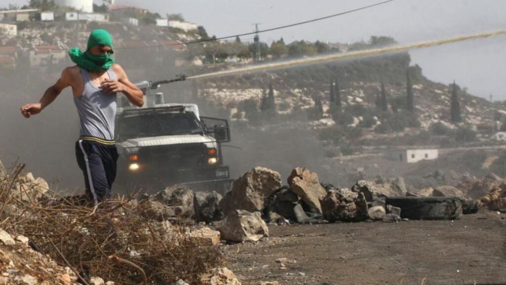 A Palestinian protester runs away from an Israeli truck firing a water cannon near Nablus earlier this week. Photograph: Abed Omar Qusini/Reuters