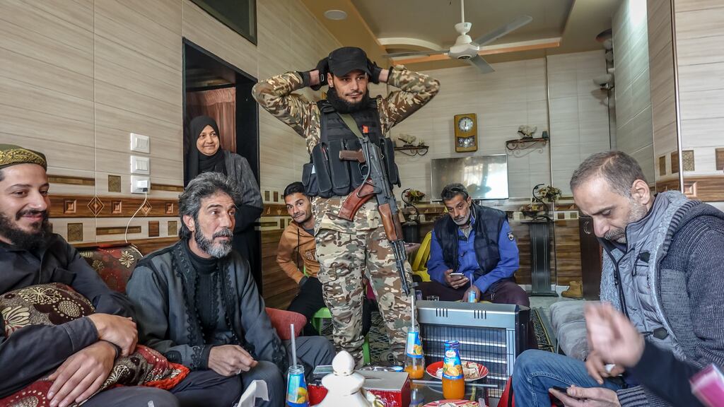 A family gathers in Hama: Moustafa Ogit (far left), Ghada Alali (third from left), Ahmad Ogit (fourth from left), Alaa Ogit (centre, with gun), and Abd Alrazzaq Taftanazy (far right). Photograph: Sally Hayden