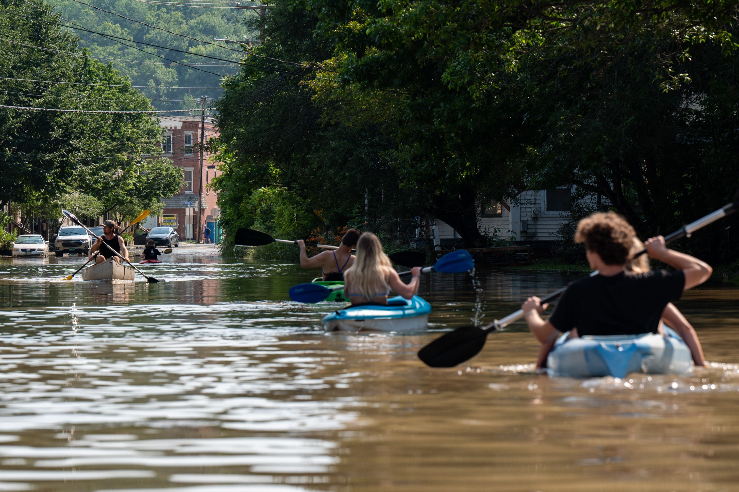 People kayak up and down the flooded waters of Elm Street in Montpelier, Vermont. Up to eight inches of rain fell over 48 hours. Photograph: Kylie Cooper/Getty Images