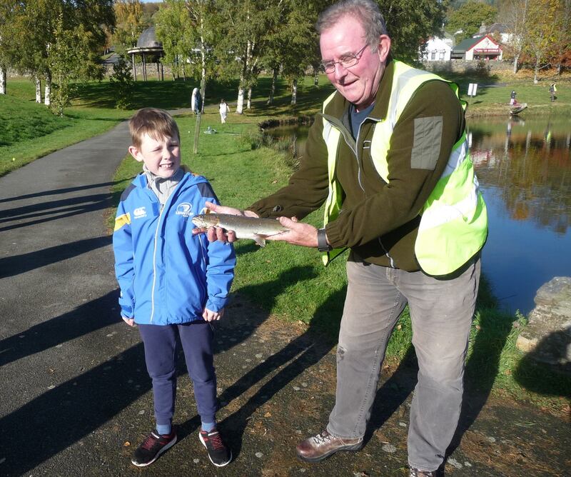 Leon Noctor, aged nine, with his first ever fish, assisted by fisheries officer Gerry Wynne at Aughrim Lake