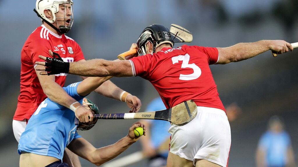 Dublin’s Ronan Hayes is tackled by Colm Spillane and Tim O’Mahony of Cork. Photo: Laszlo Geczo/Inpho