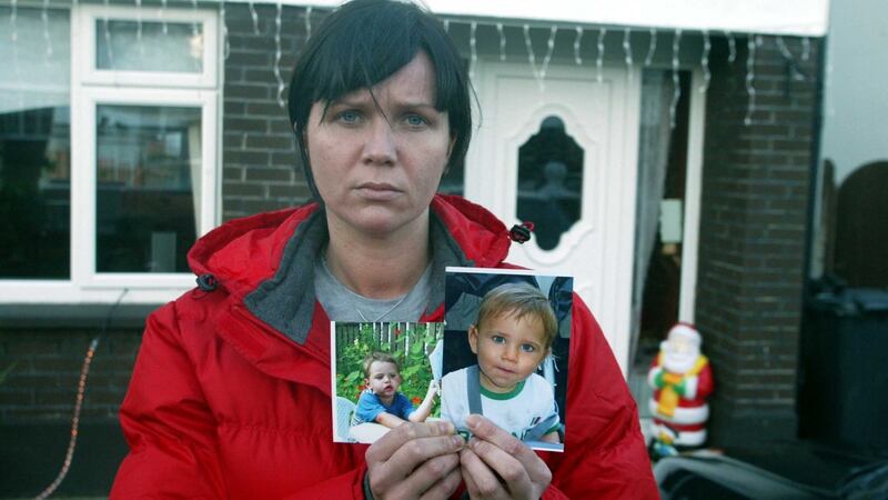 Baiba Saulite holds photographs of her children after their abduction. Photograph: Collins