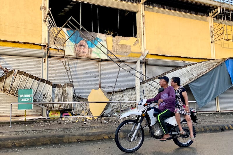 Residents look at a store damaged by the earthquake in Bayugan City, Agusan del Sur, southern Philippines. Photograph: Ivy Marie Mangadlao/AP