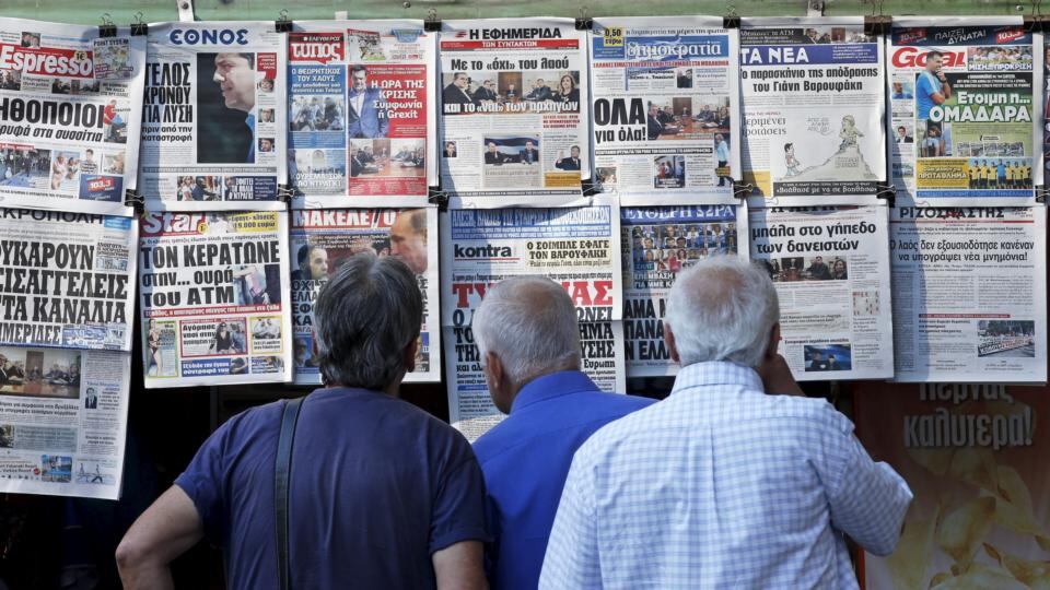 People read the front pages of various newspapers hanging at a kiosk in central Athens, on Tuesday. Greece faces a last chance to stay in the euro zone on Tuesday when prime minister Alexis Tsipras puts proposals to an emergency euro zone summit. Photograph: Reuters