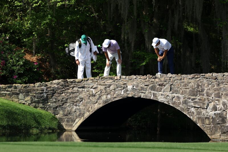 Scottie Scheffler and Sam Burns look into the water on the famous 13th hole during a practice round prior to the 2024 Masters at Augusta National. Photo by Warren Little/Getty Images