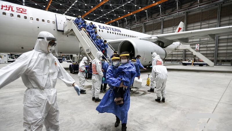 A handout photo made available by the Ministry of National Defence shows soldiers in protective suits disinfecting people from a China Eastern Airlines plane after it landed at Taoyuan International Airport in Taoyuan City, Taiwan. Photograph: Taiwan ministry of national defence/ Handout