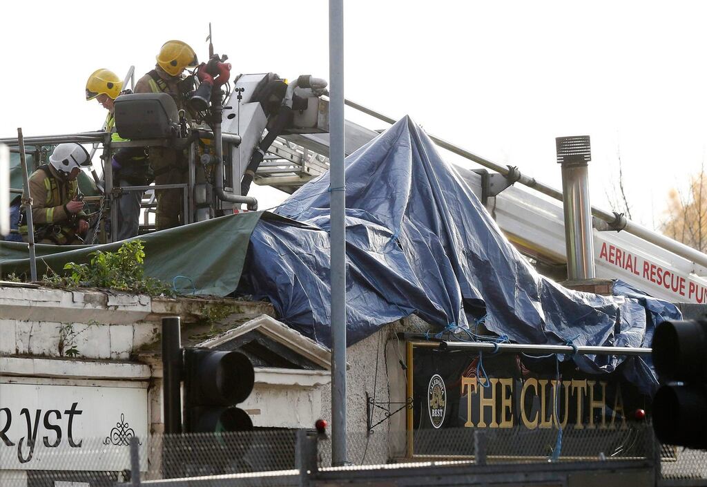 Members of the emergency services use a cherry picker to access the crash site of a police helicopter on the roof of a pub in the centre of Glasgow, Scotland. Photograph: Andrew Winning/Reuters