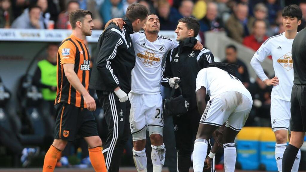 Swansea City’s Kyle Naughton is carried off after picking up an injury during the Barclays Premier League match at the Liberty Stadium. Photo: Nick Potts/PA