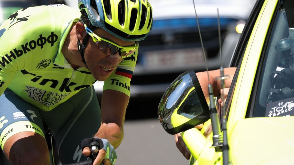 Spain’s Alberto Contador listens to a member of his team driving next to him as he rides during the ninth stage of the of the Tour de France. The two-time winner quit the race later on the stage. Photograph: Kenzo Tribouillard/AFP