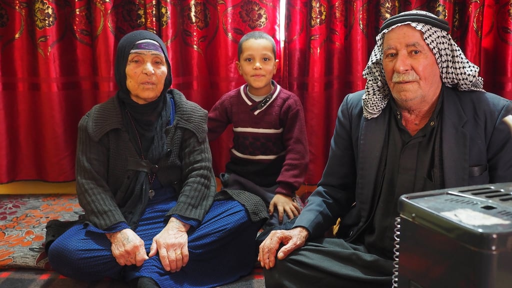 Khalaf and Barnu Al-Hadedi with their grandson in their living room in the Al-Nabi Younis neighbourhood  of Mosul. Photograph: Lorraine Mallinder