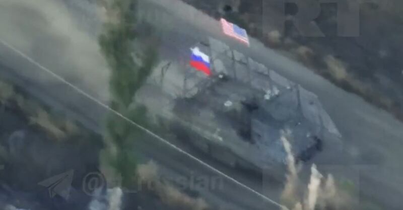 A still from a viral video - also broadcast on Russian state media - showing a captured tank with a US and Russian flag