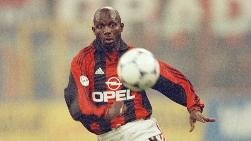 George Weah playing soccer during his earlier international career.
