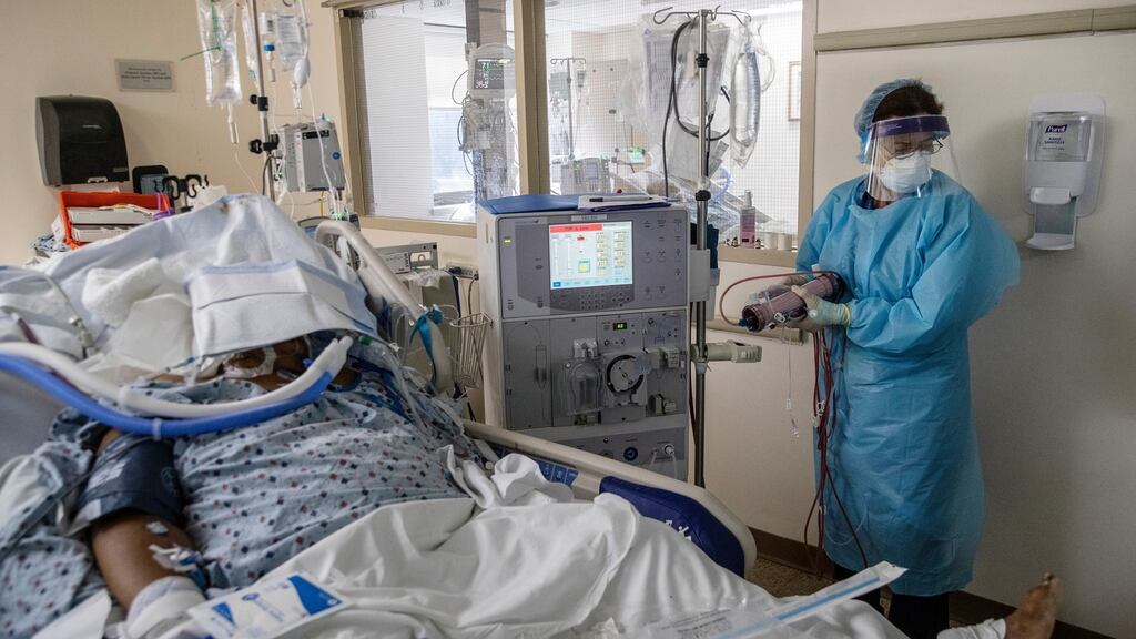 Miriam Figueroa, a dialysis nurse at the Brooklyn Hospital Center, tends to a Covid-19 patient in the intensive care unit, in Brooklyn. Photograph: Victor J Blue/The New York Times
