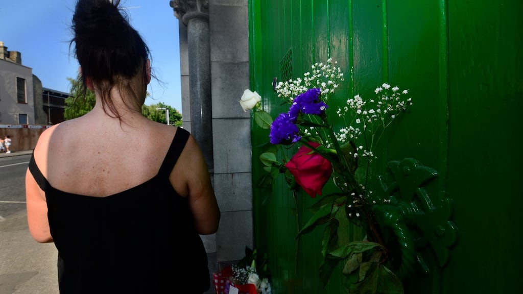 A former resident outside the laundry at Sean McDermott Street, where there are  posies and a bouquet left at the door in memory of women who spent their lives inside. Photograph: Cyril Byrne / The Irish Times