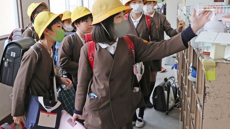 Elementary school children disinfect their hands before leaving school in Osaka on Friday. Photograph: Jiji Press/AFP