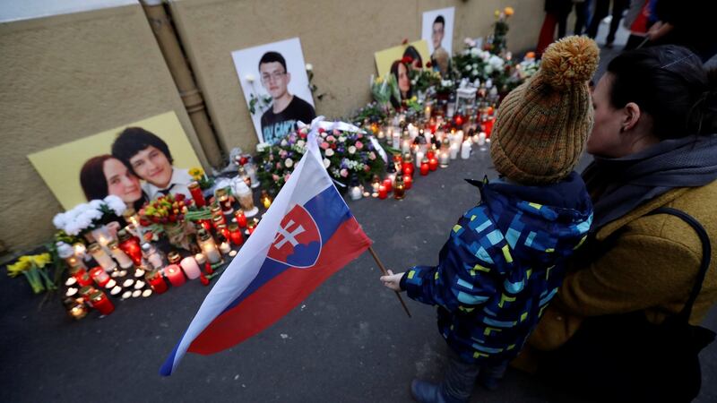A child holds a Slovakian flag by a memorial on the first anniversary of the murder of the investigative reporter Jan Kuciak and his partner Martina Kusnirova, in Bratislava. Photograph: David W Cerny/Reuters