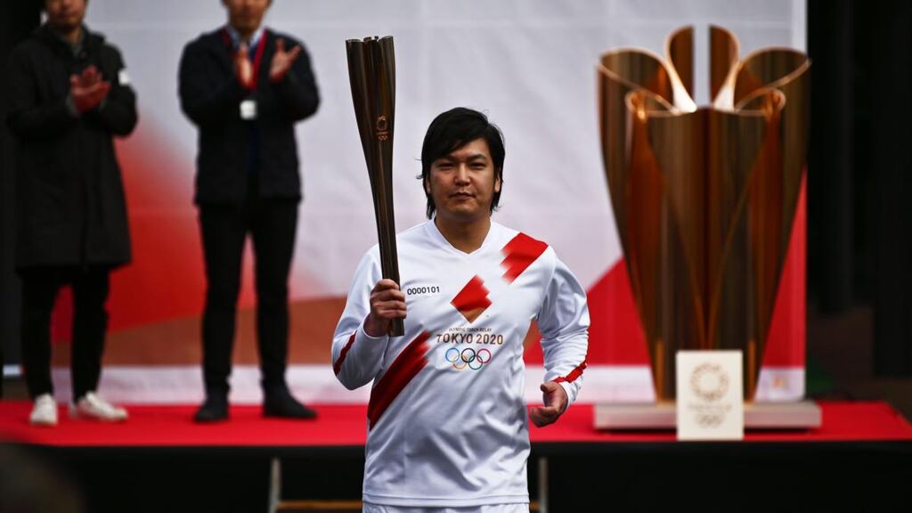 A runner holds the Olympic torch during a rehearsal for the Tokyo 2020 Olympics torch relay. Photograph: Getty Images