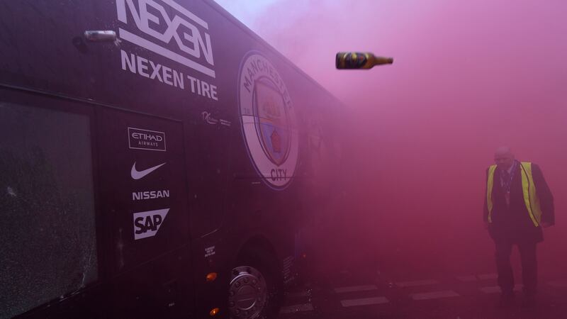 Bottles and cans are thrown at the bus as Manchester City players arrive at Anfield for Uefa Champions League tie. Photograph: Getty Images