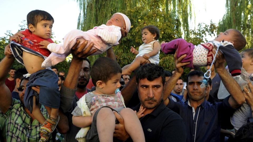 Migrants lift their children as they protest to be allowed to cross into Greece near the Turkish border in Edirne, on Sunday. Photograph: Reuters