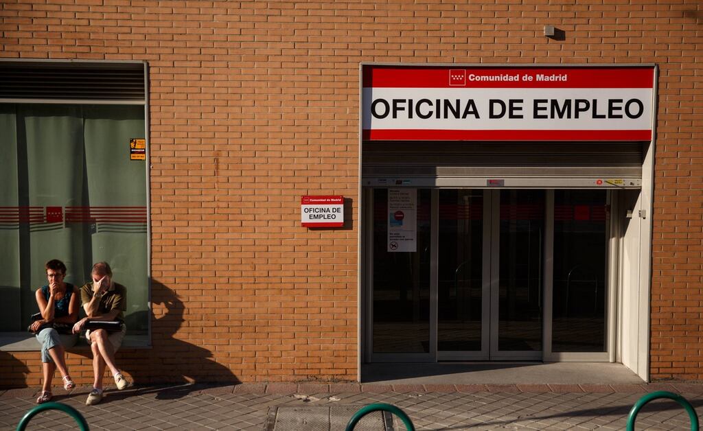 People sit in front of a government-run employment office in Madrid yesterday. A strong start to the tourist season helped Spain’s unemployment rate fall to its lowest in two years, while two banks with large local customer bases said business had picked up. Photograph: Andrea Comas/Reuters