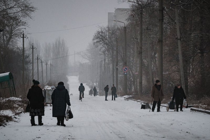 People walk along a snow covered street in Bakhmut, in the Donetsk region, amid the Russian invasion of Ukraine. Photograph: Yasuyoshi Chiba/AFP