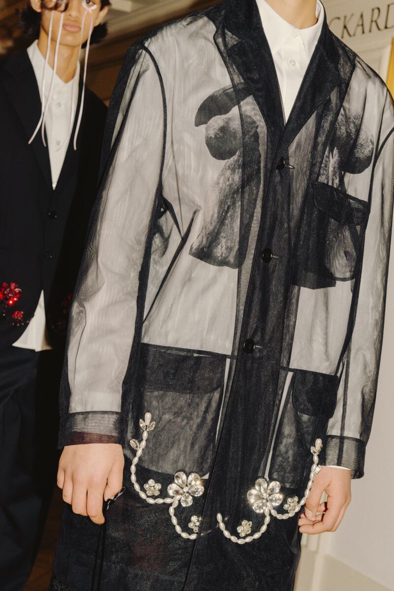 Black tulle sheer overcoat with pearl and crystal embellishment €1605, white cotton poplin shirt with graphic print €455, corded lace boxing shorts €800