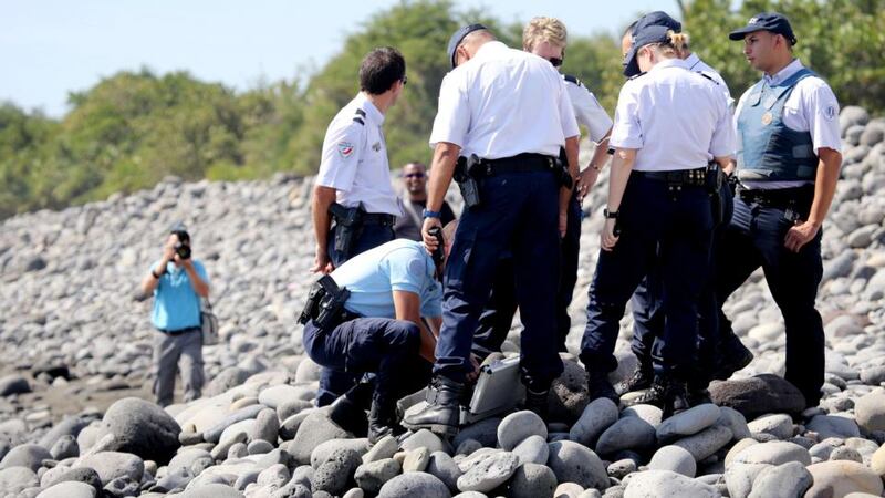 Officers inspect debris found on a beach in Saint-Denis, Reunion Island on Sunday. Photograph: Richard Bouhetrich Bouhet/AFP/Getty