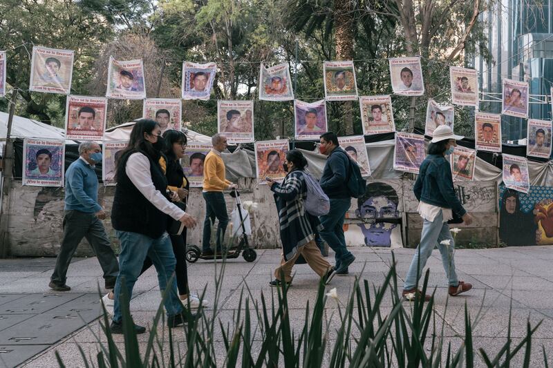 People walk past images of the 43 students who disappeared in 2014, in Mexico City. Photograph: Luis Antonio Rojas/The New York Times