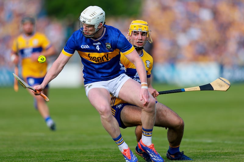 Michael Breen of Tipperary keeps possession despite pressure from Clare's Mark Rodgers. Photograph: Natasha Barton/Inpho