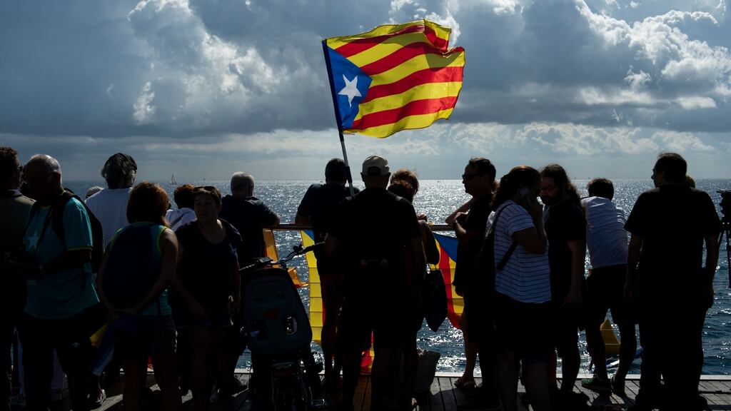 People hold “Esteladas”, Catalan pro-independence flags, as they watch boats participating in a pro-independence gathering from the Pont del Petroli in Badalona. Photograph: Josep Lago/AFP