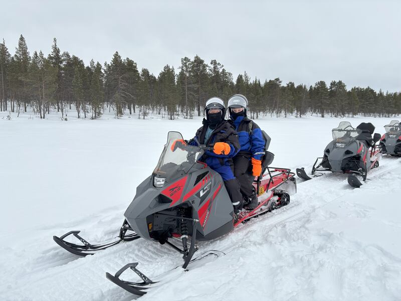 Natalie and August snowmobiling on Lake Menesjärvi, Inari, Finland
