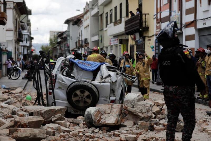 A crushed car and rubble on street following the earthquake. Photograph: AP