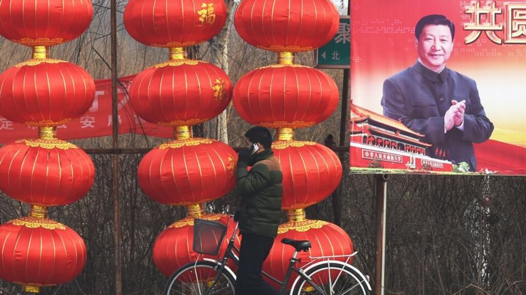 A man walks past a billboard featuring a photo of China’s president Xi Jinping beside lantern decorations for the Lunar New Year in Baoding, China’s northern Hebei province, on Tuesday. Mr Xi has unveiled his latest political slogan, the “Four Comprehensives”, a call for a more prosperous country and deeper reform. Photograph: Greg Baker/AFP/Getty Images