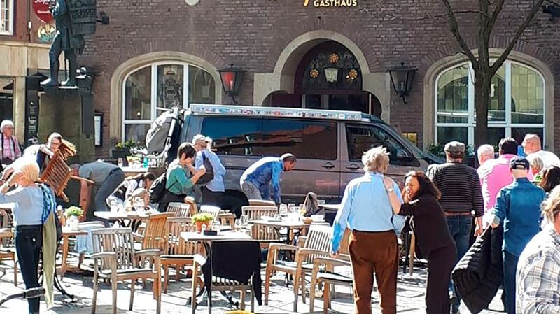 People stay in front of a restaurant in Muenster after a vehicle crashed into thecrowd. Photograph: Stephan R/dpa via AP
