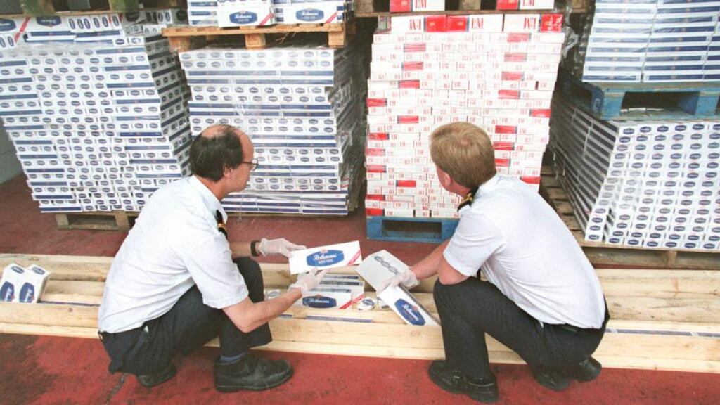 Customs officers examine a haul of cigarettes seized by the national drugs team, discovered on board a vessel that arrived in Dublin from Latvia. Photograph: Eric Luke