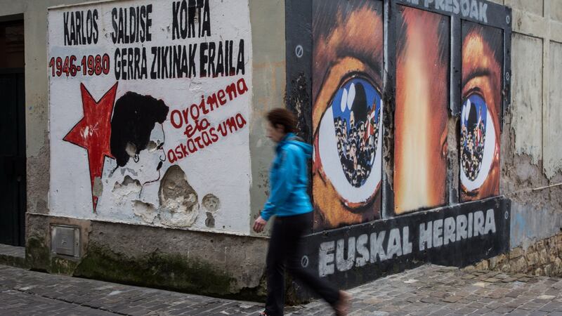A woman walks past a wall with Eta graffiti in San Sebastian, Spain, in March 2017. Photograph: Javi Julio /Anadolu Agency/Getty Images