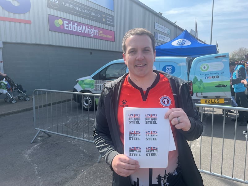 Matthew Cook, a Community Union worker, hands out stickers in support of the steelworkers before Scunthorpe's match with Spennymoor. Photograph: Mark Paul