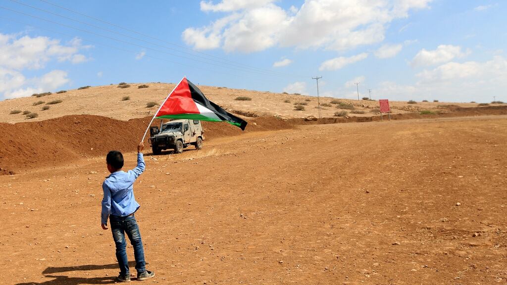 A Palestinian boy waves a Palestine flag during clashes following a protest against the expropriation of Palestinian land in the village of Atouf, near the west bank city of Tubas, on Wednesday. Photograph: Alaa Badarneh/EPA