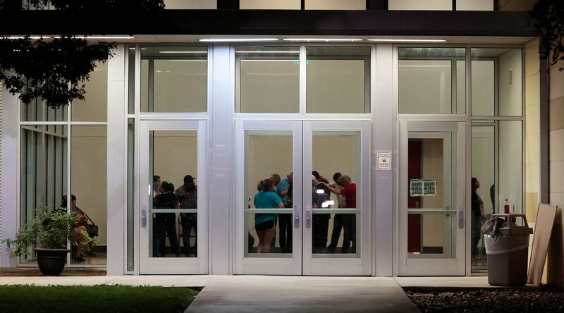 People embrace inside the SSGT Willie de Leon Civic Center as investigators continue to work at the scene of a mass shooting at the Robb Elementary School, in Uvalde, Texas.