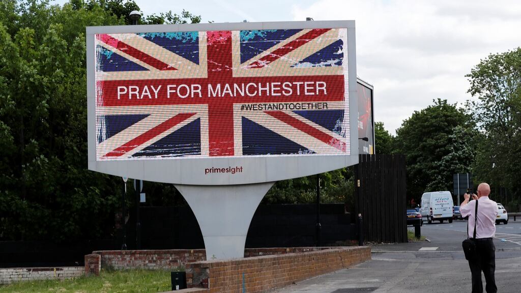 A man photographs a sign in Manchester, Britain May 23, 2017. REUTERS/Stefan Wermuth