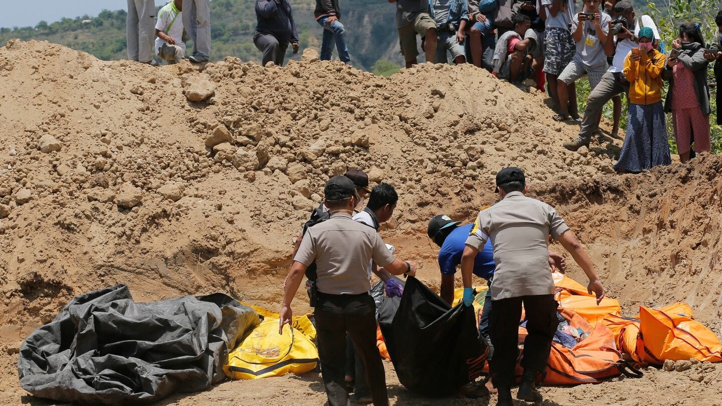 Rescue teams carry the bodies of victims to a mass grave following a major earthquake and tsunami in Palu, Central Sulawesi, Indonesia. Photograph: Tatan Syuflana/AP