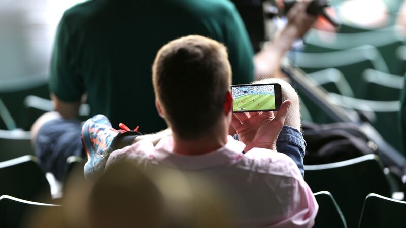 A tennis fan watches England’s World Cup quarter-final win over Sweden while at Wimbledon. Photograph: Steven paston/PA