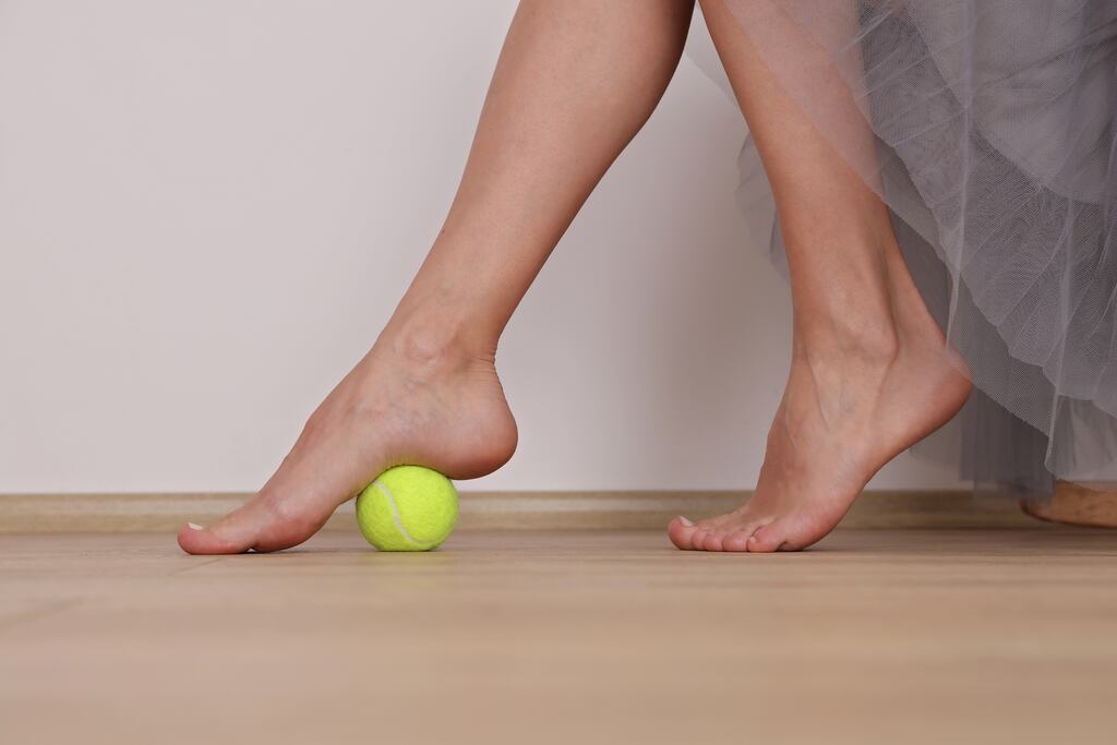 Rolling your feet over a tennis ball is a great starting point to wake up your feet.