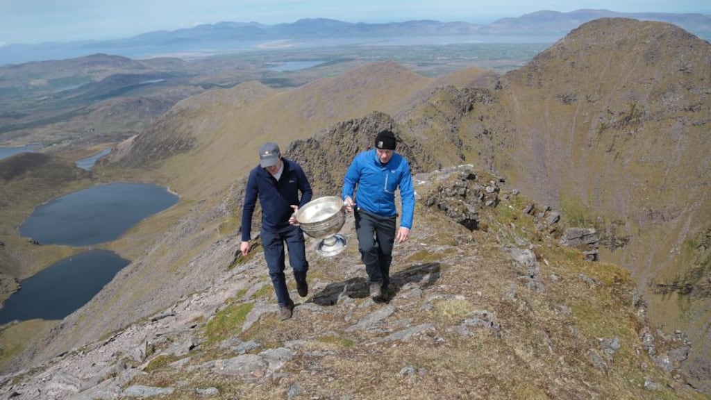 Cork’s Graham Canty, left, and former Kerry footballer Séamus Moynihan carry the Sam Maguire Cup to the summit of Carrauntoohil, Co Kerry, during the ‘Sam to Summit’ in aid of the Alan Kerins Project. Photo:  Valerie O’Sullivan/Sportsfile